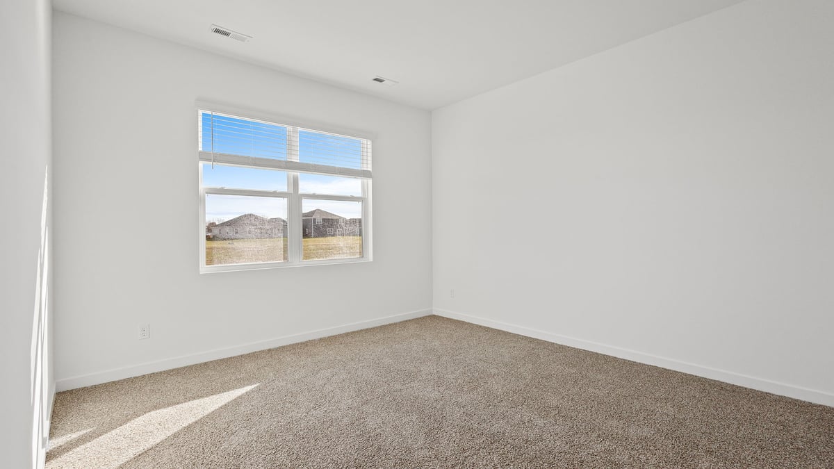 Primary bedroom with carpeted floors.