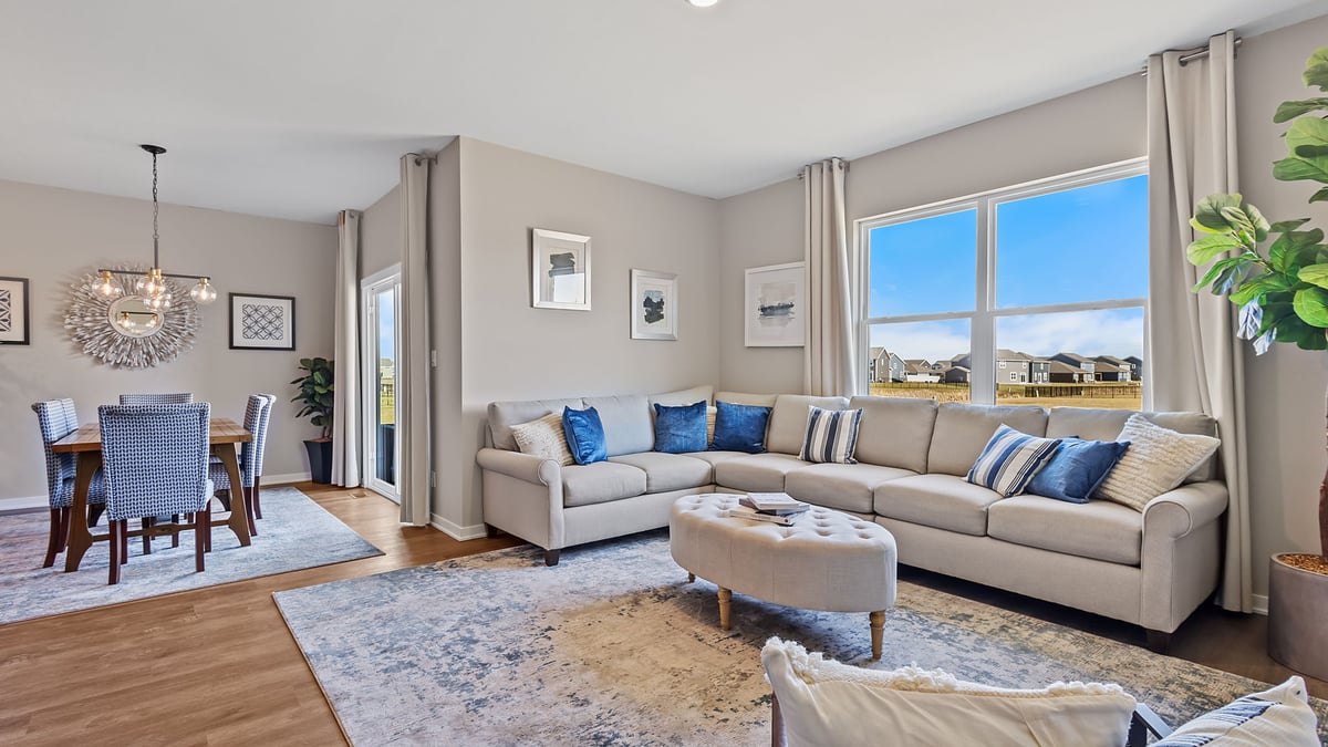 Living room area with a big window and hard wood flooring.