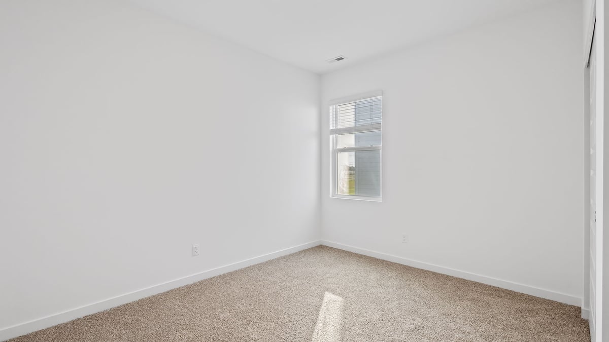 Bedroom with one window and carpeted floors.