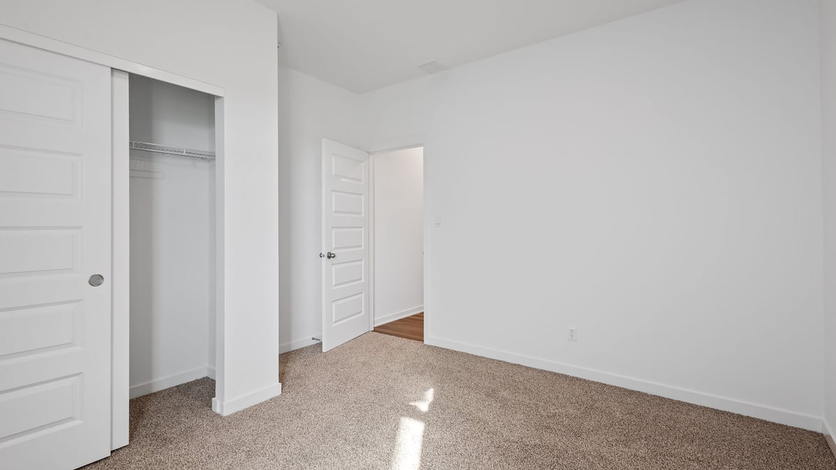 Bedroom with carpeted floors and a closet.