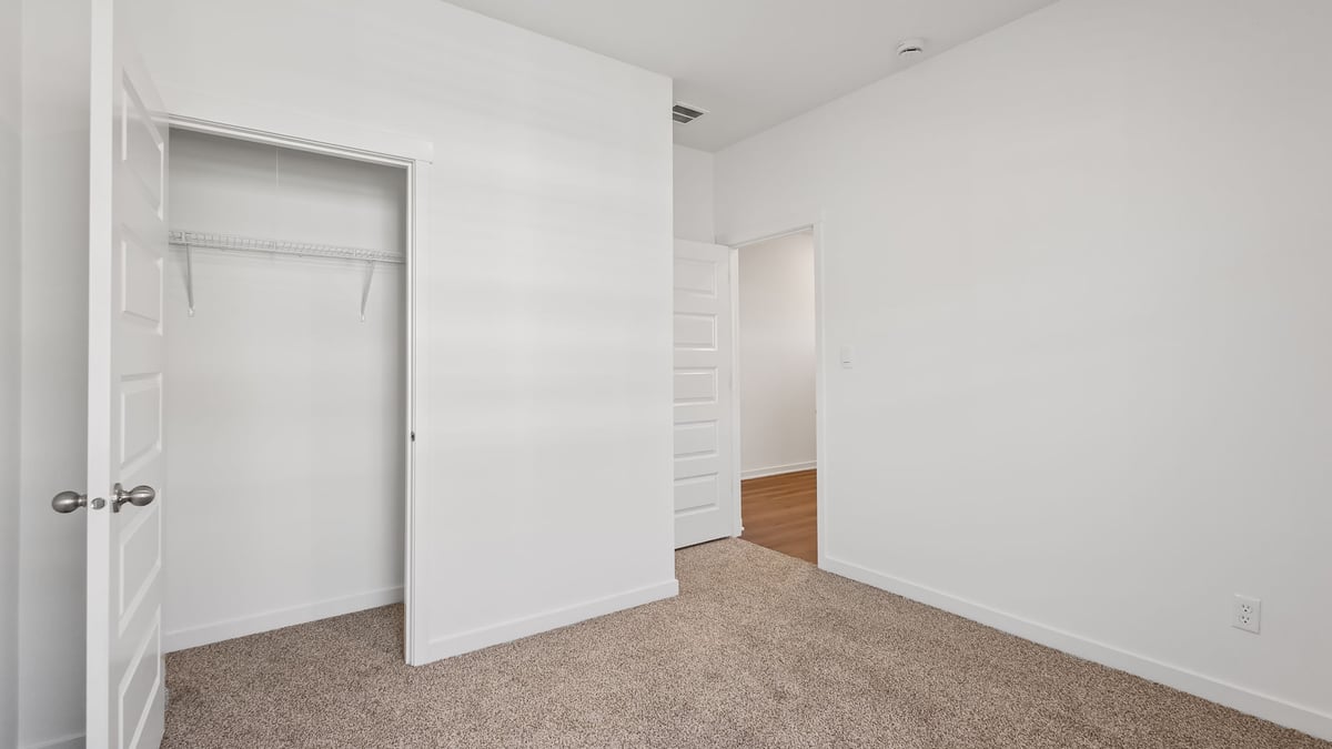 Bedroom with carpeted floors and a closet.