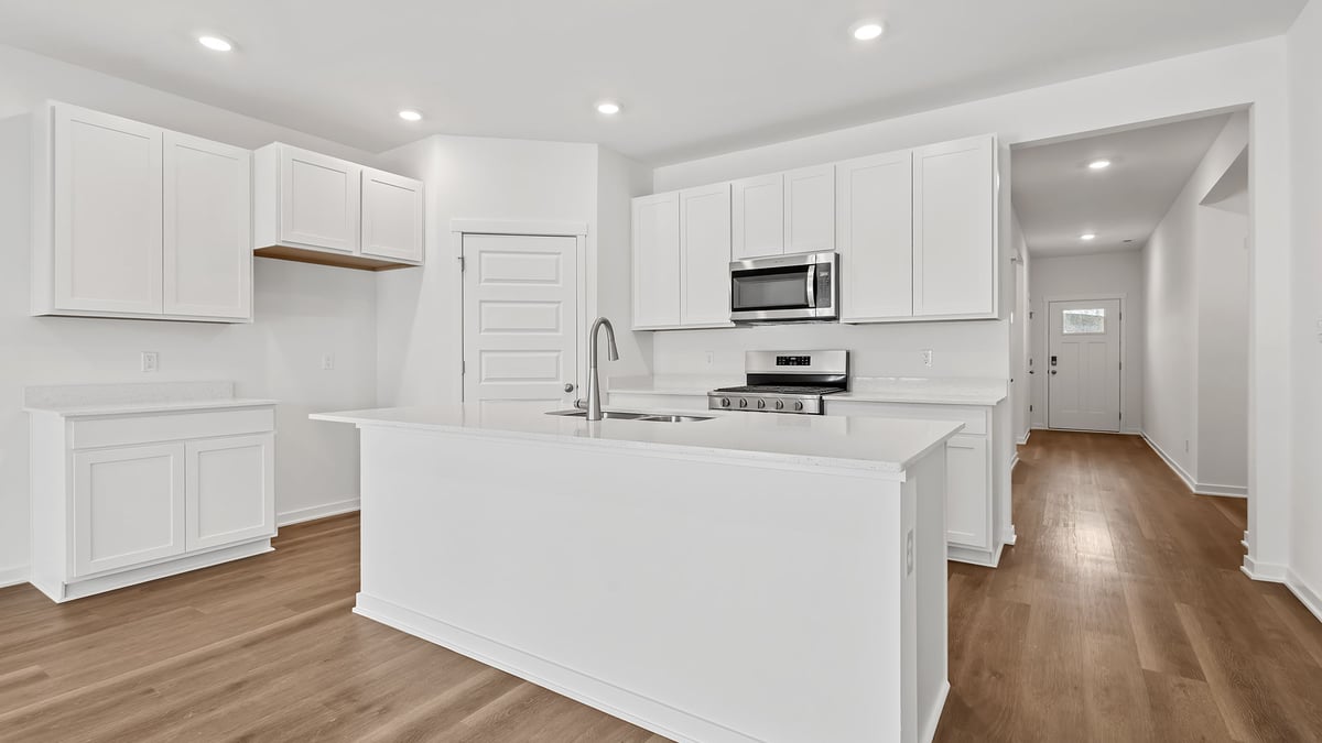 Kitchen with white cabinets and quartz countertops.