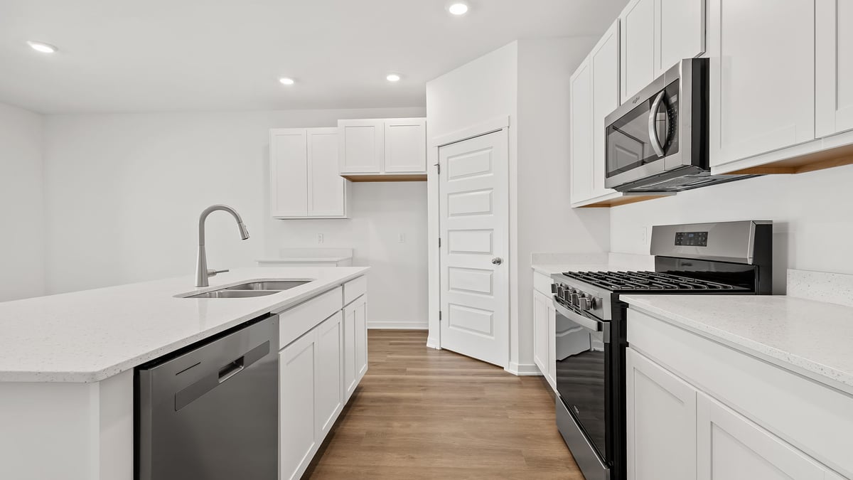 Kitchen with white cabinets with quartz countertops.
