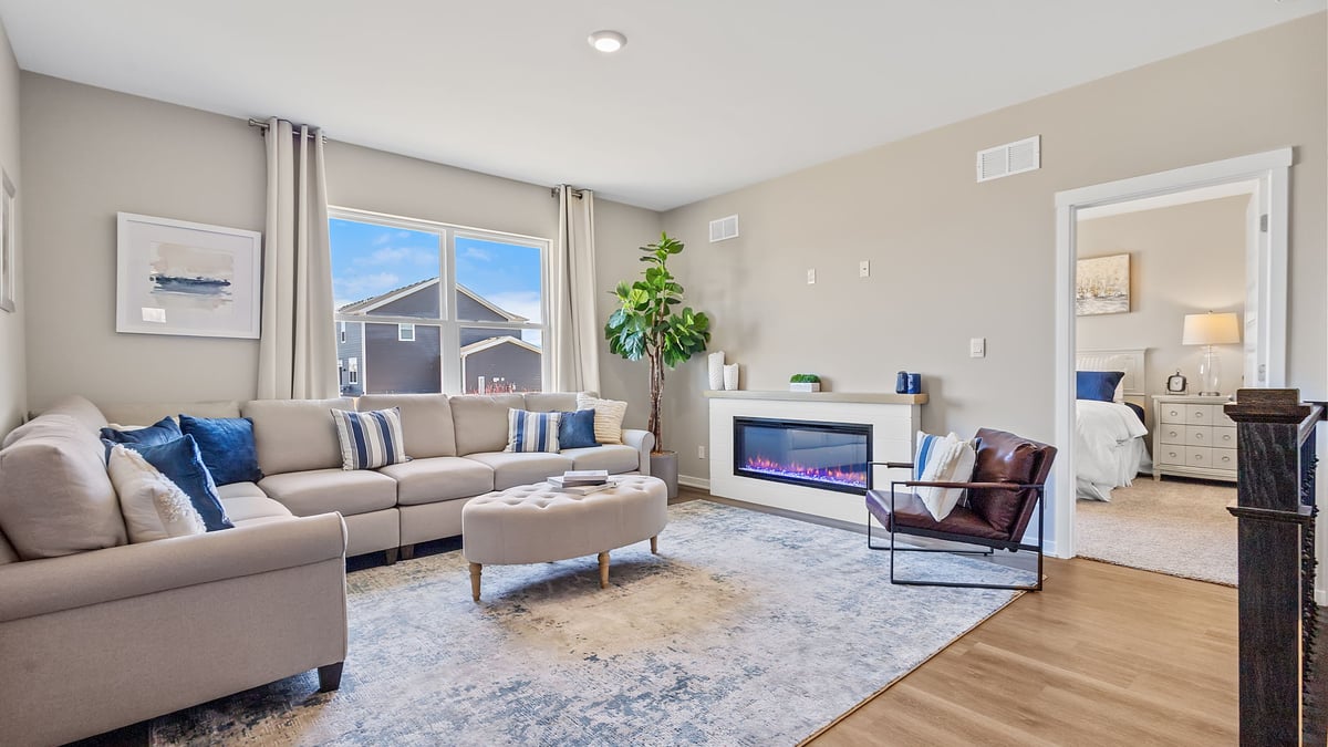 Living room area with hard wood floors and a big window.