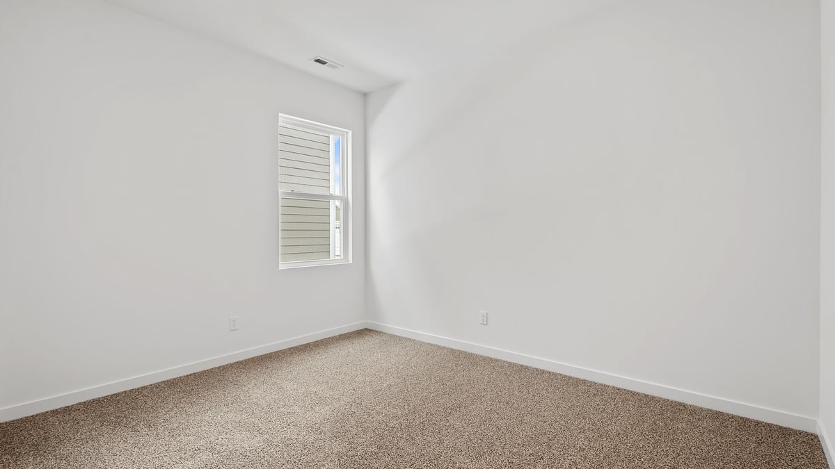 Bedroom with carpeted floors with a side window.