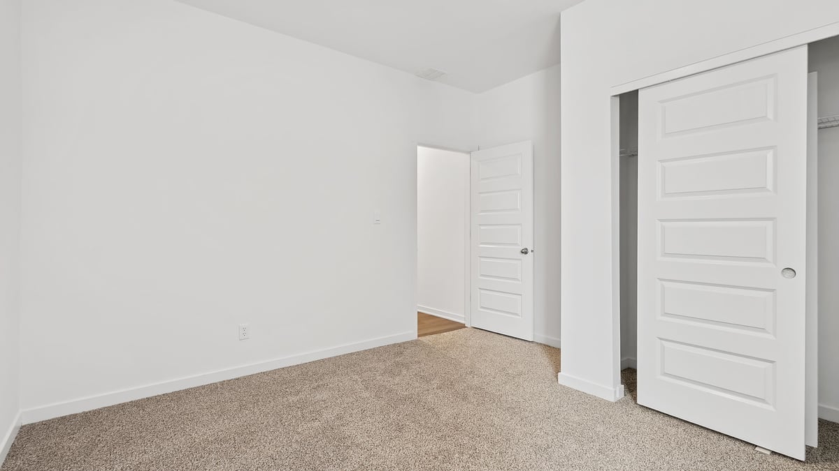 Bedroom with carpeted floors and a closet.