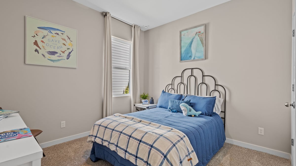 Bedroom with a side window and carpeted floors.