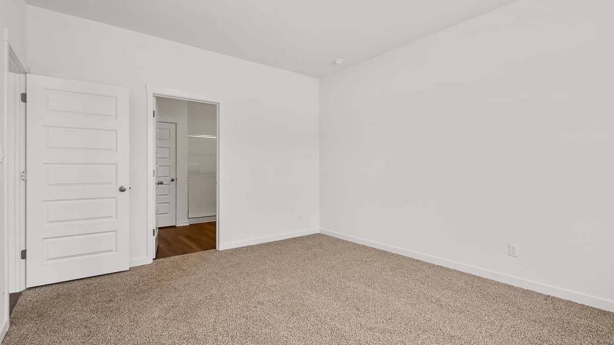 Bedroom with carpeted floors and a side bathroom.