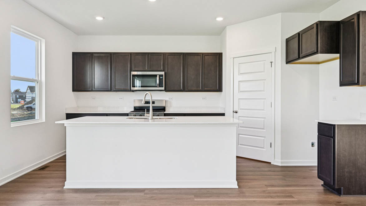 Kitchen with brown cabinetry and island.