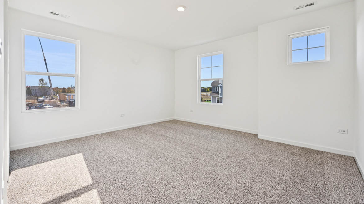 Bedroom with open layout and windows with carpet.