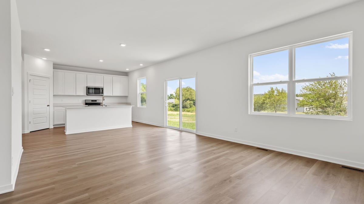 Open concept with windows and hard wood flooring.