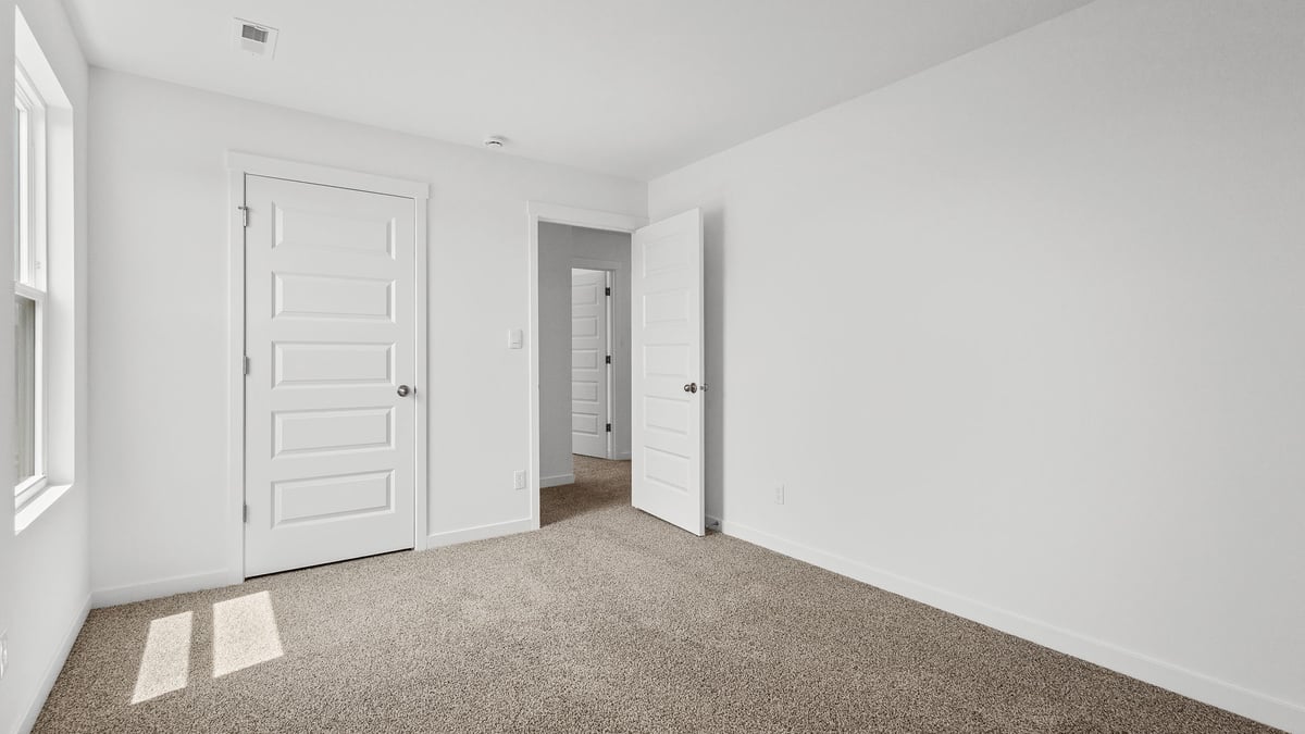 Bedroom with closet and carpeted floors.