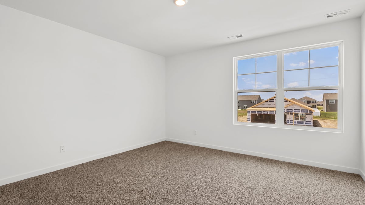 Bedroom with one big window and carpeted floors.