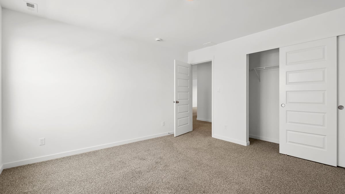 Bedroom with carpeted floors and closet.