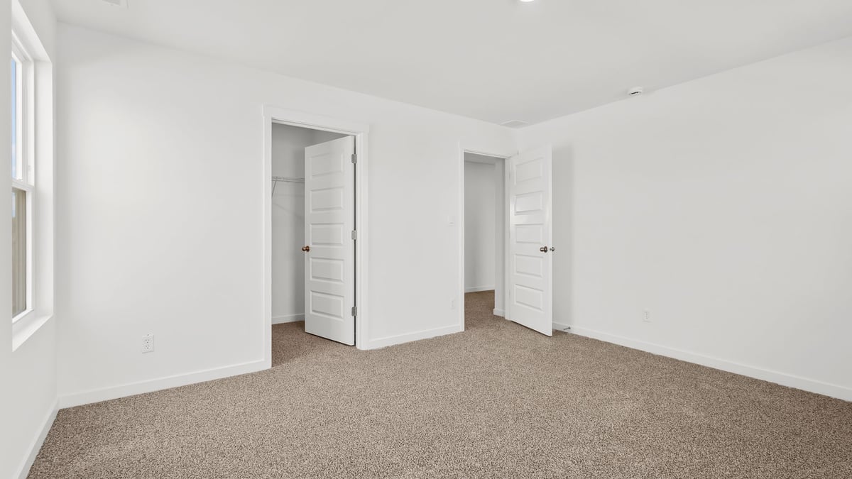 Bedroom with closet and carpeted floors.