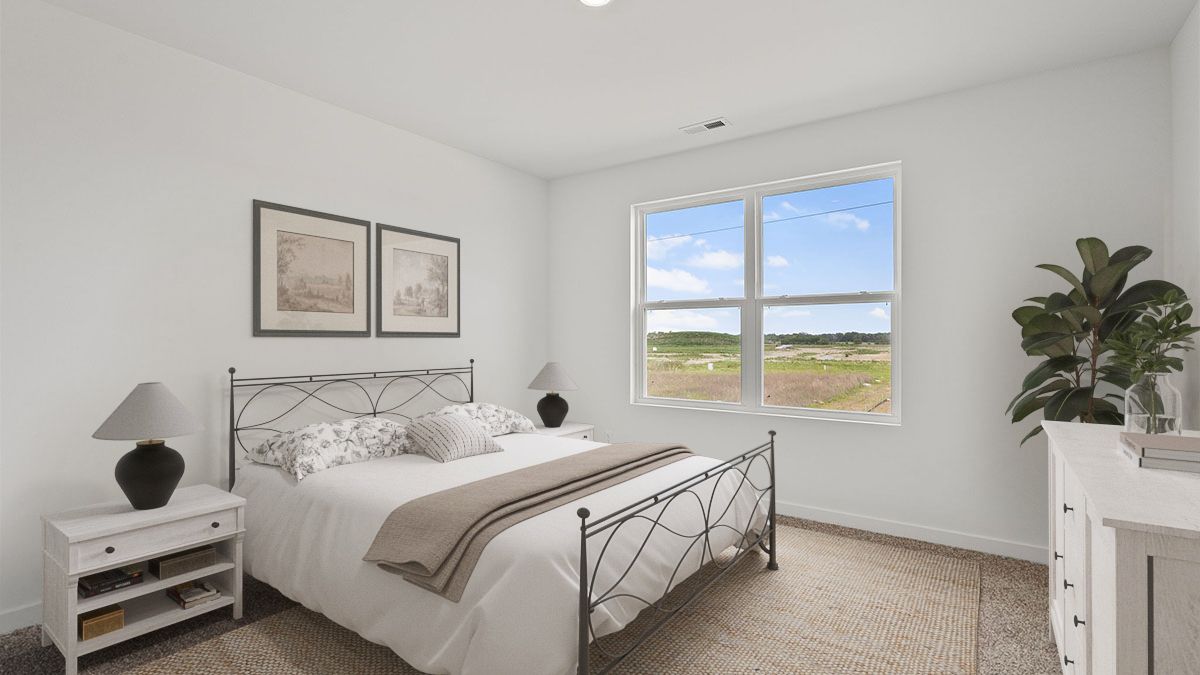 Bedroom with carpeted floors with a big window.