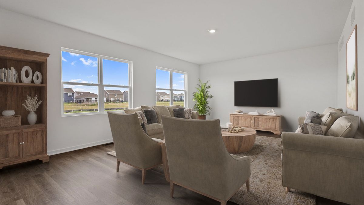 Living rom with hard wood floors and multiple windows.
