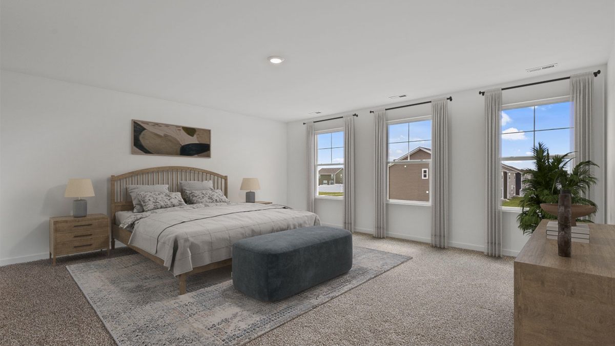 Primary bedroom with carpeted floors and big windows.