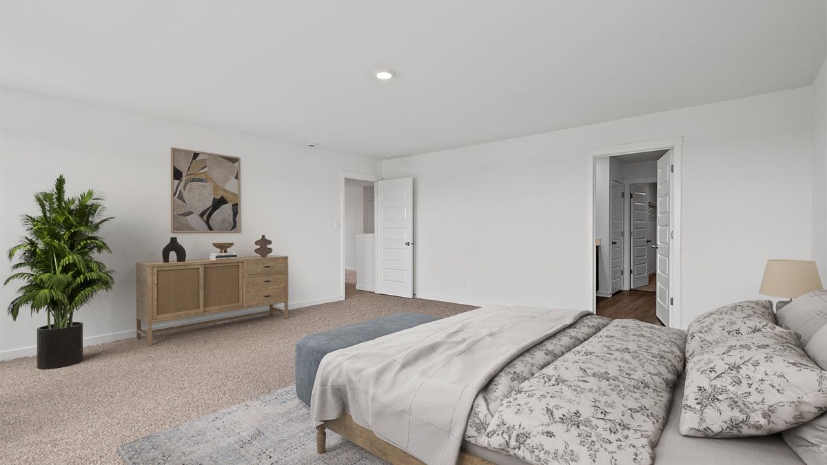 Primary bedroom with carpeted floors with a bathroom suite.