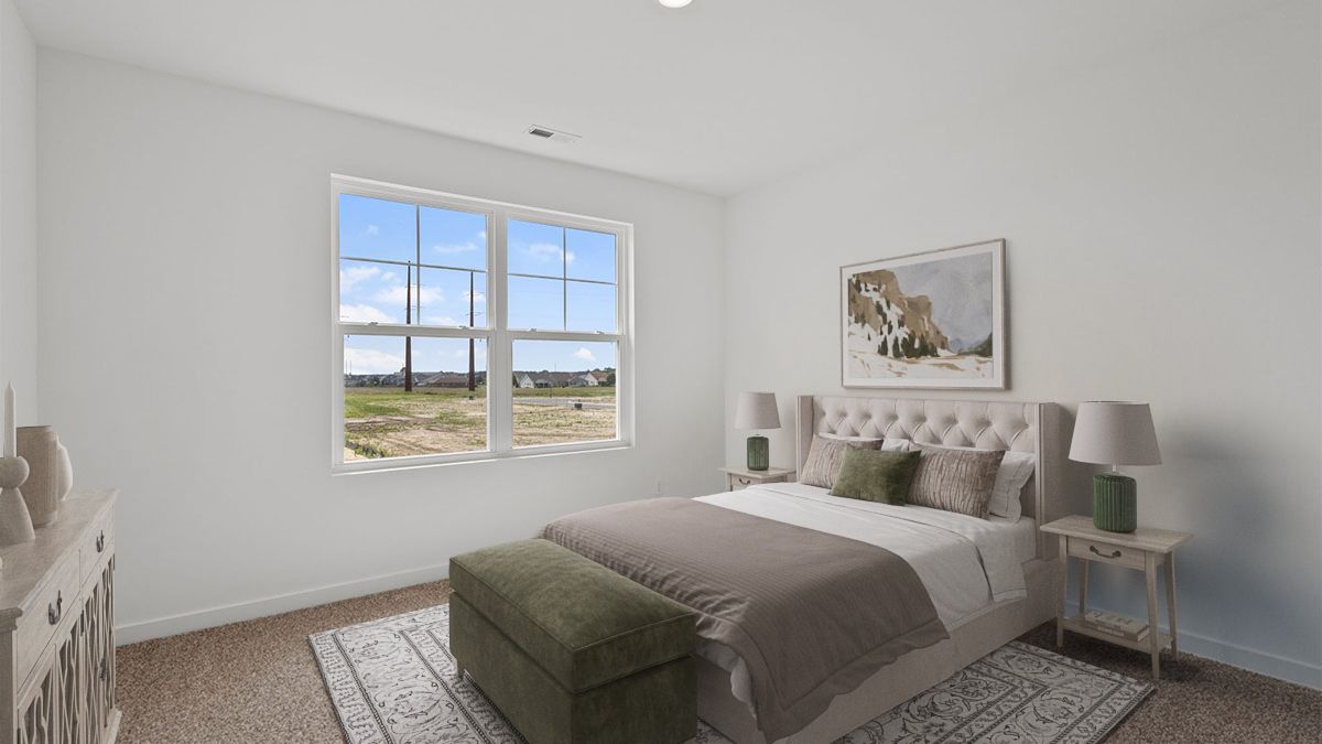 Bedroom with carpeted floors with a big window.
