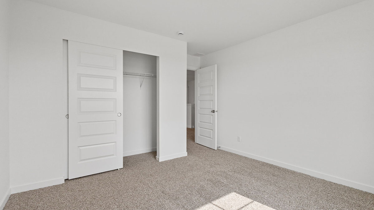 Bedroom with a closet and carpeted floors.