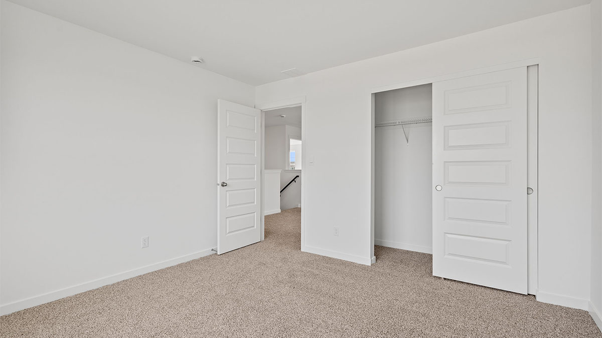 Bedroom with carpeted floors and a closet.