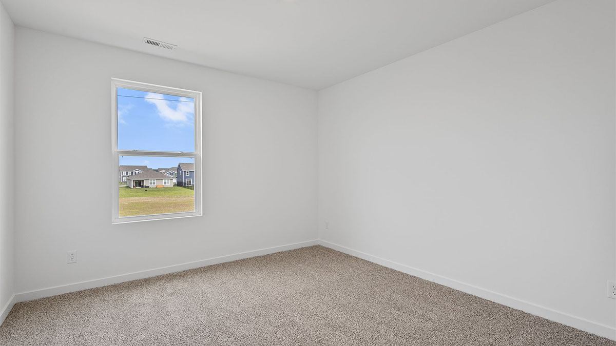 Bedroom with carpeted floors and a window.