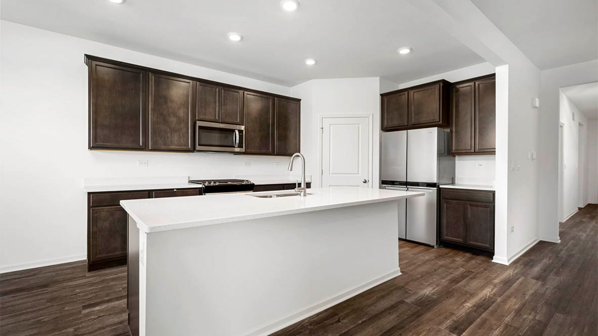 Kitchen with brown cabinetry with quartz countertops.