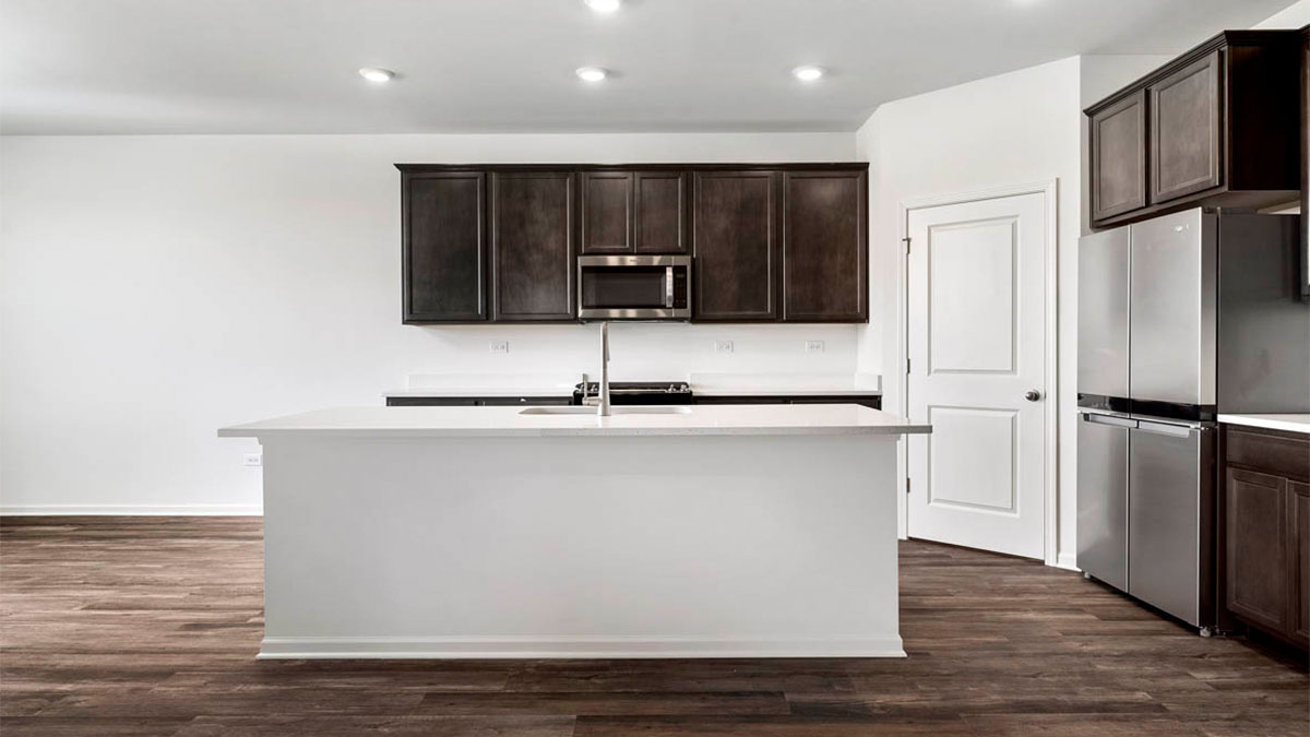 Kitchen with brown cabinets and kitchen island with quartz countertops.