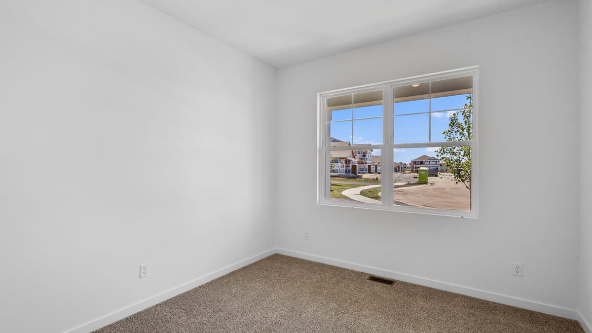Bedroom with carpet and windows.
