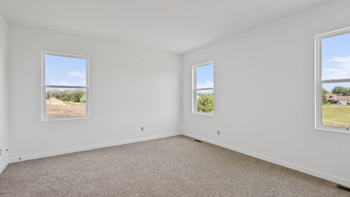 Room with carpet and three windows.