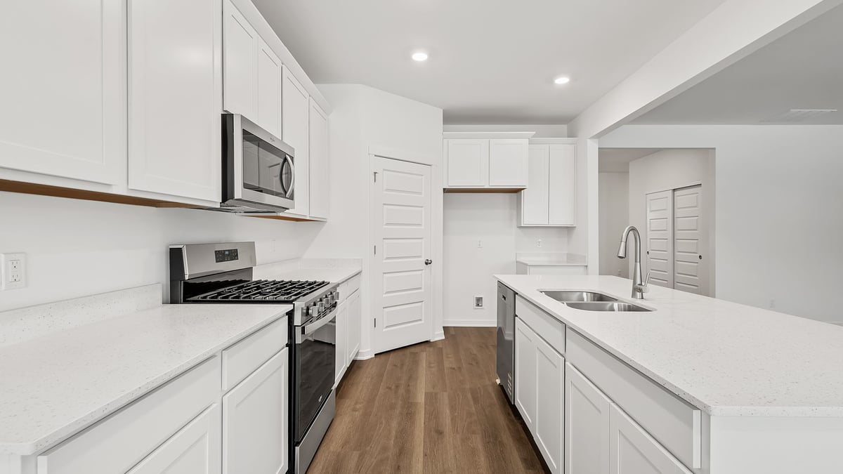Kitchen with white cabinets and quartz countertops.