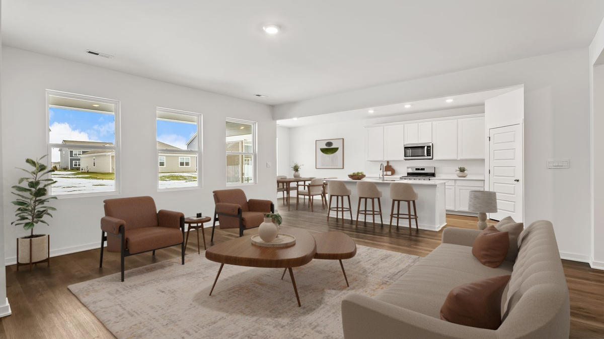 Living room and kitchen area with white cabinets and two windows.