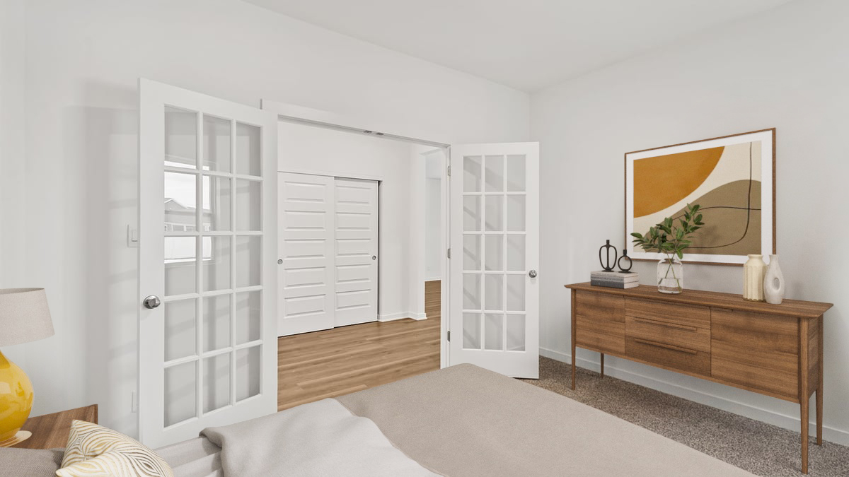 Bedroom with french doors and carpeted floors.
