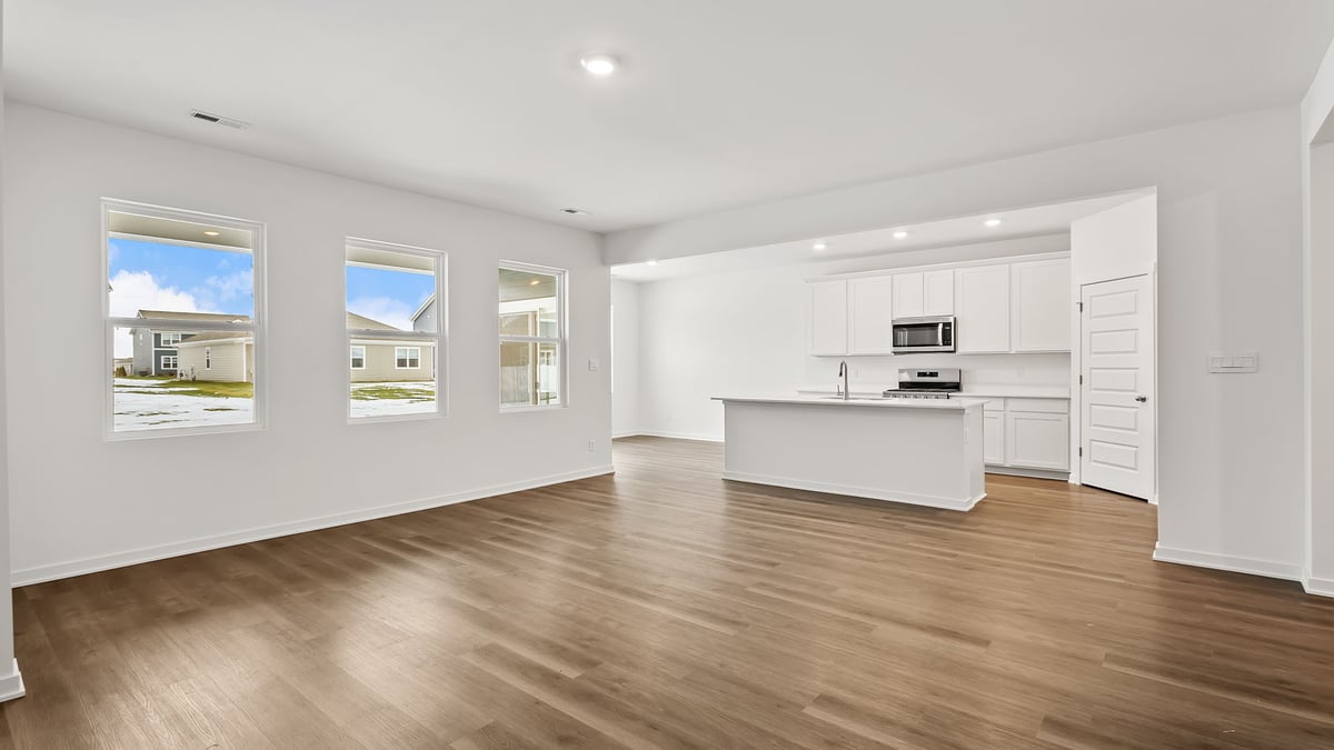 Living room area with hard wood flooring and side windows.