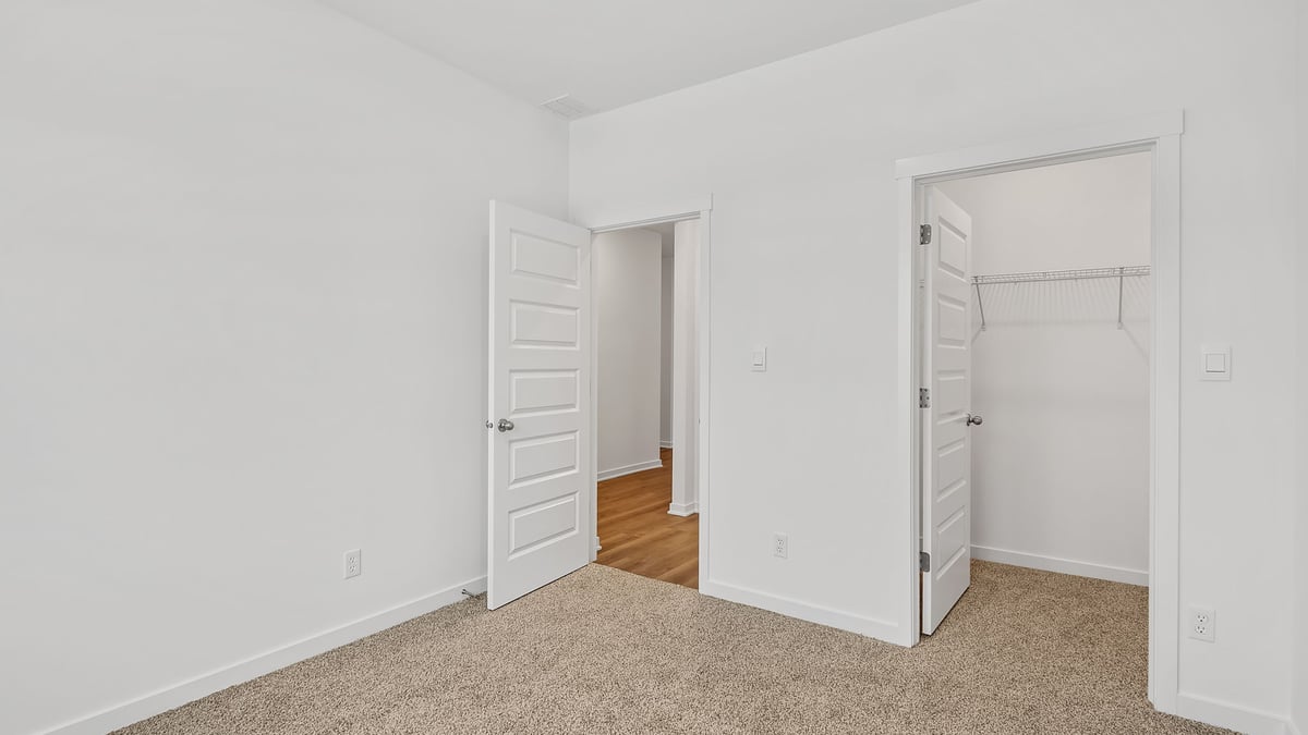 Bedroom with carpeted floors and a closet.