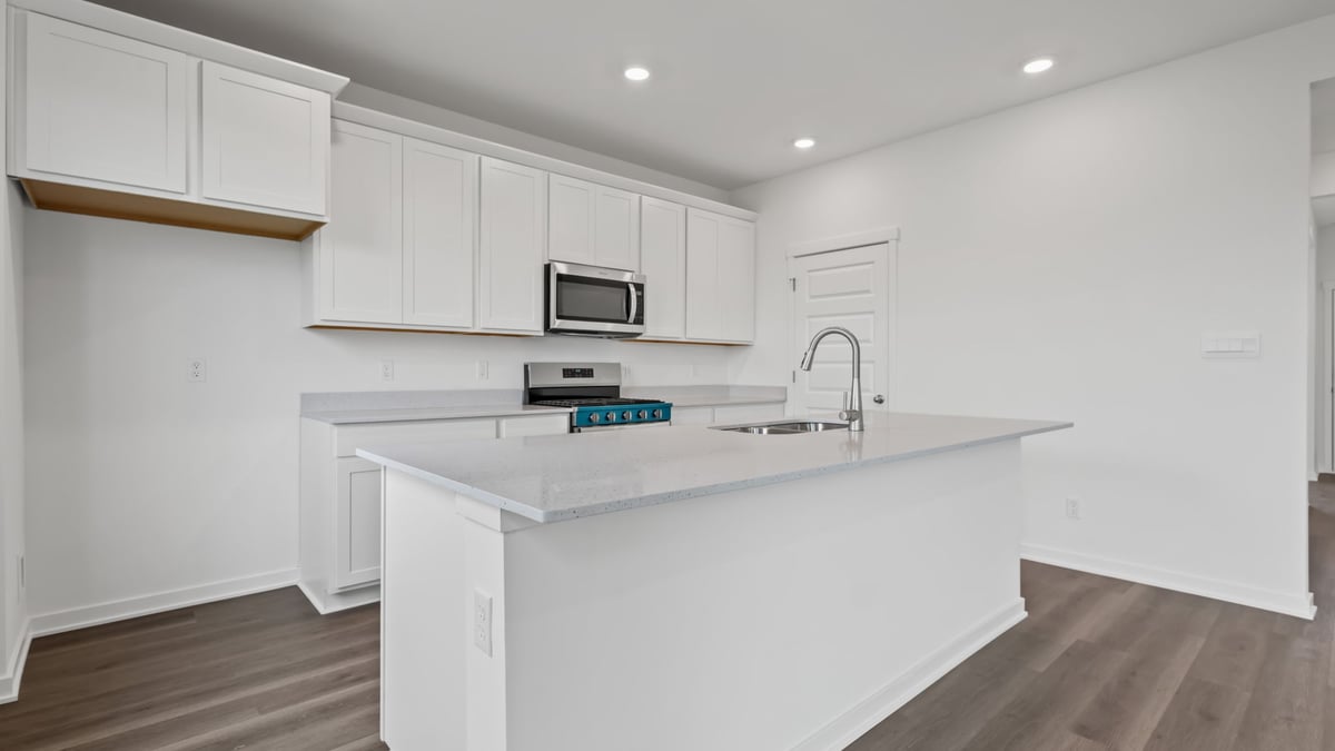 Open kitchen with an island and white cabinetry.