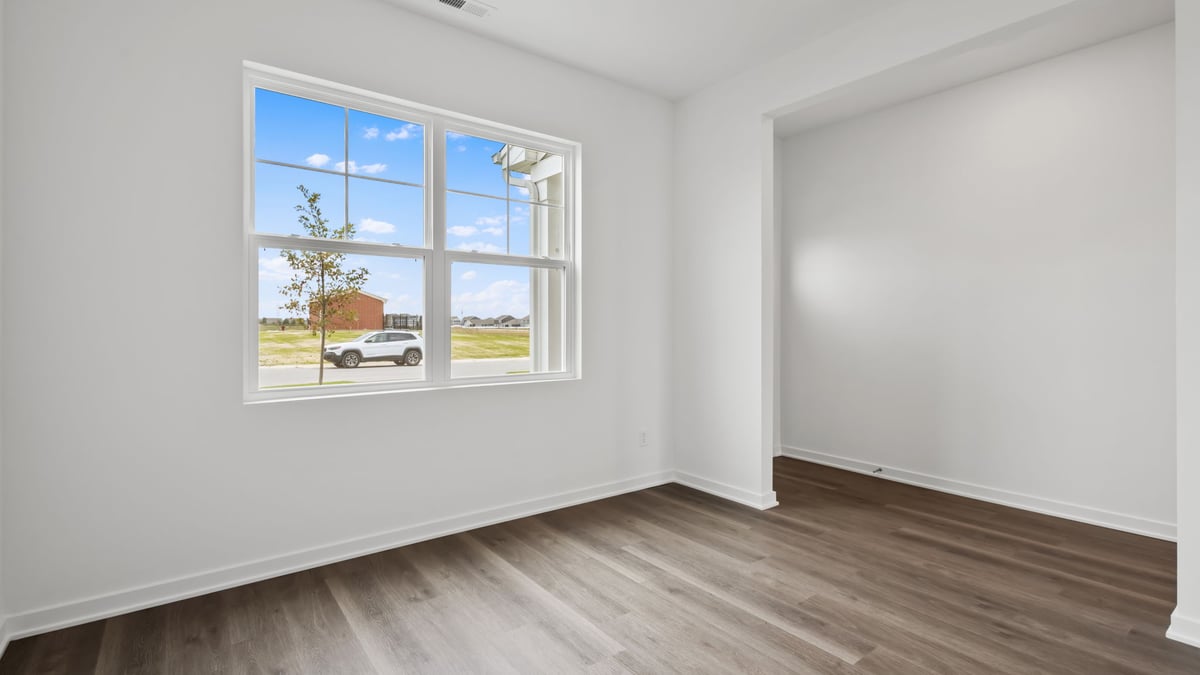 Front room of home with windows and hard wood floors.
