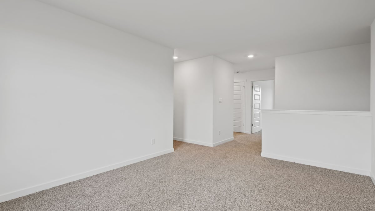 Loft room with carpeted floors and open concept.