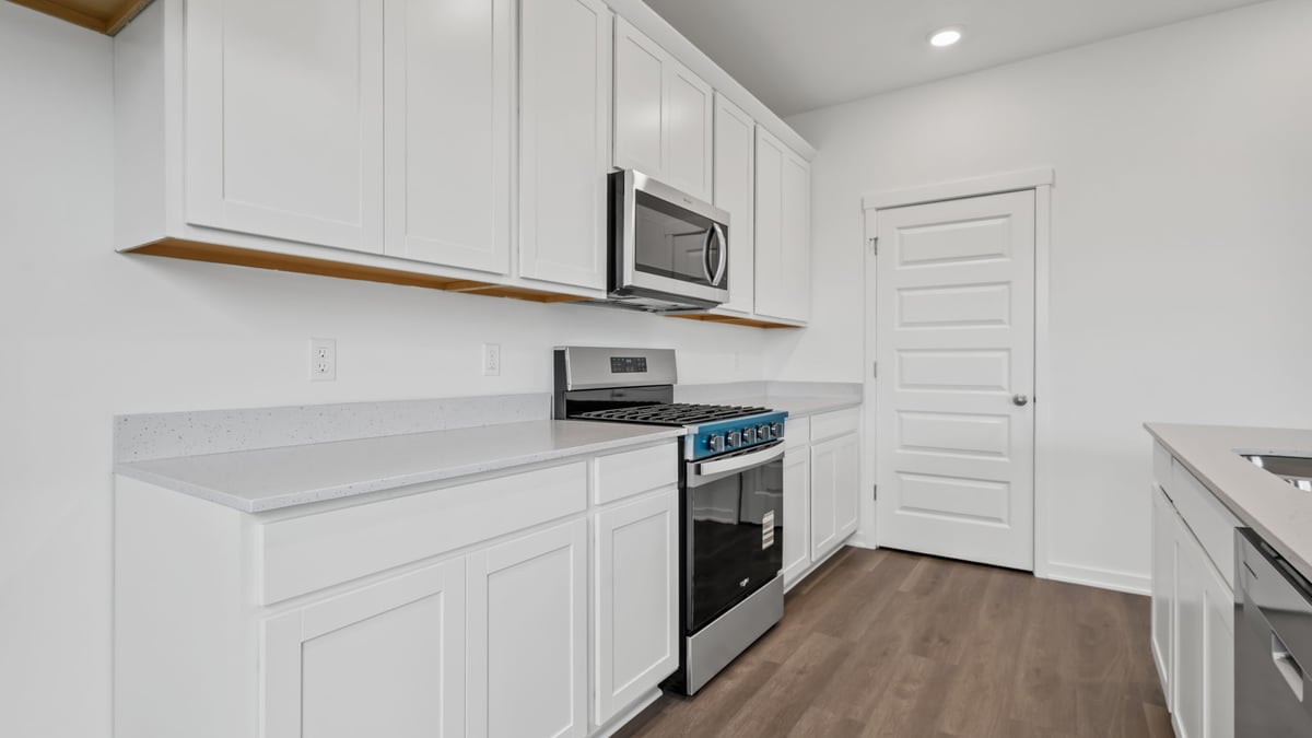 Kitchen with white cabinetry and microwave.
