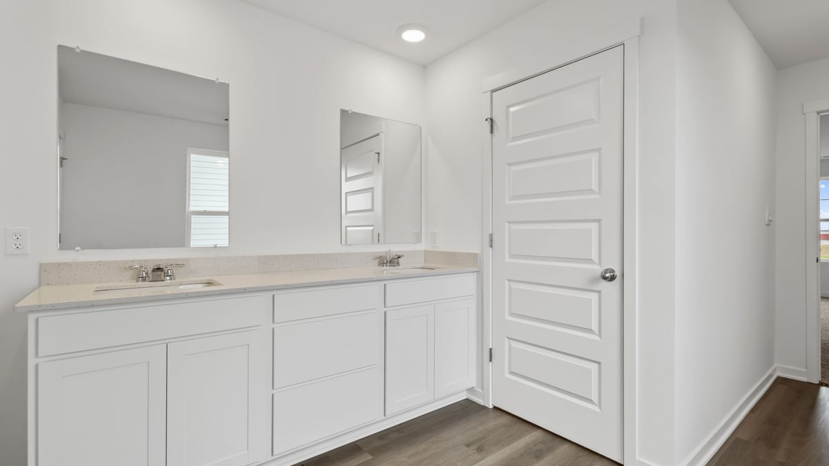 Bathroom with dual vanity sink and a walk in shower.