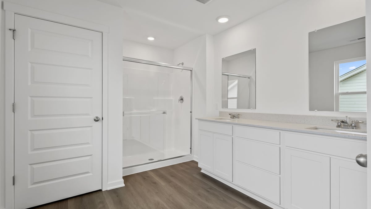 Bathroom with dual vanity sink and a walk in shower.