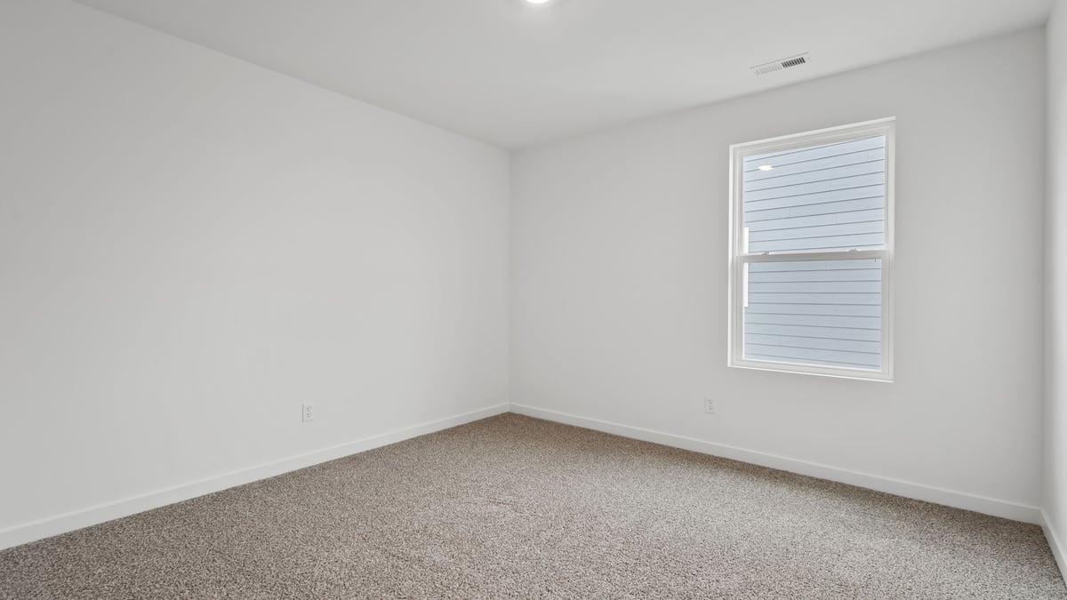 Bedroom with window and carpeted floors.