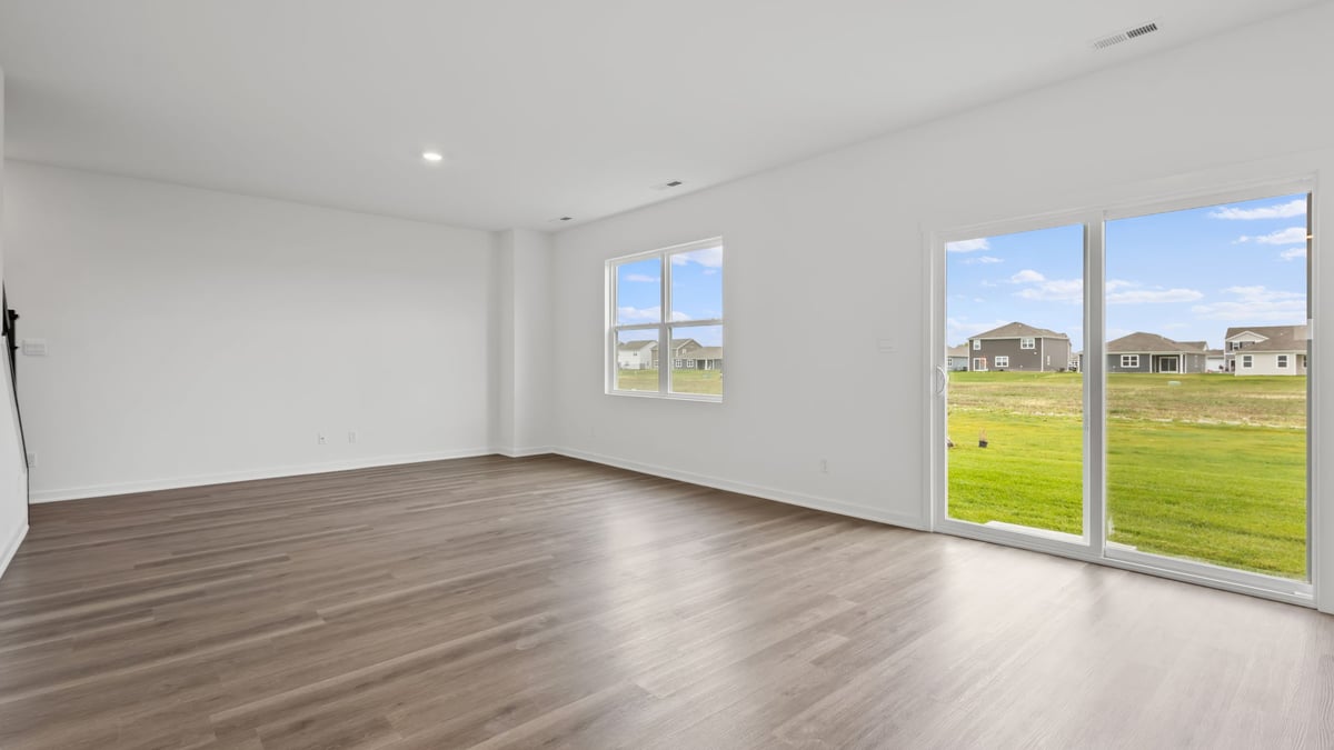 Open living room with windows and sliding glass door.