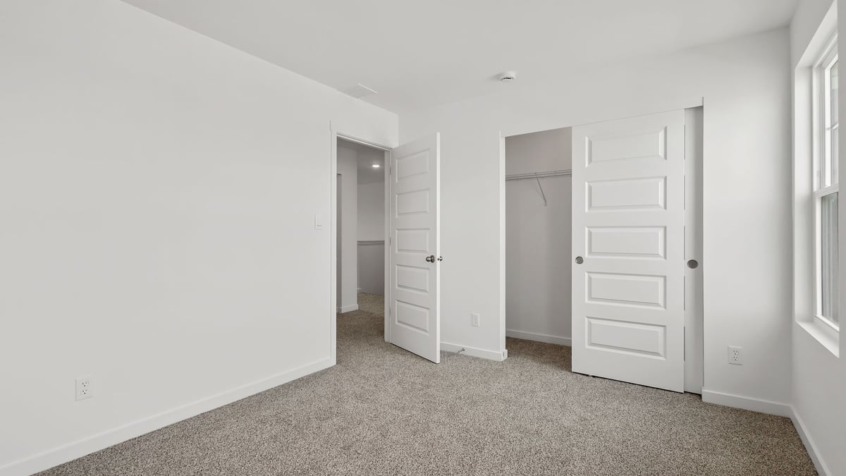 Bedroom with carpeted floors and a closet.