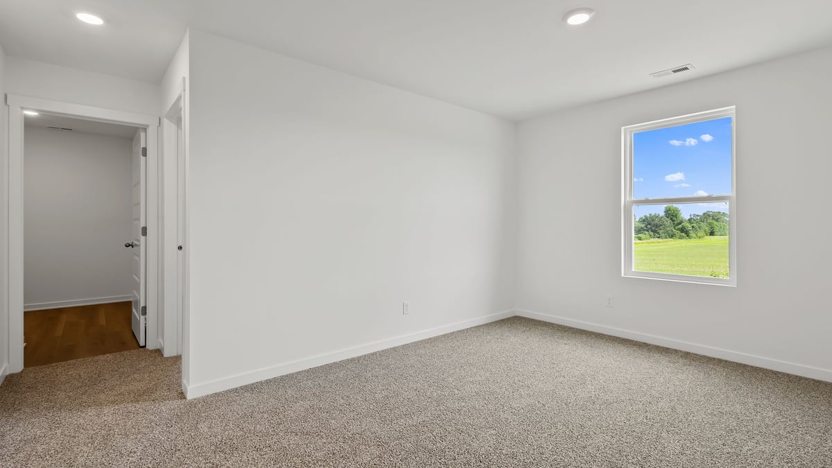 Loft area with carpeted floors and a side window.