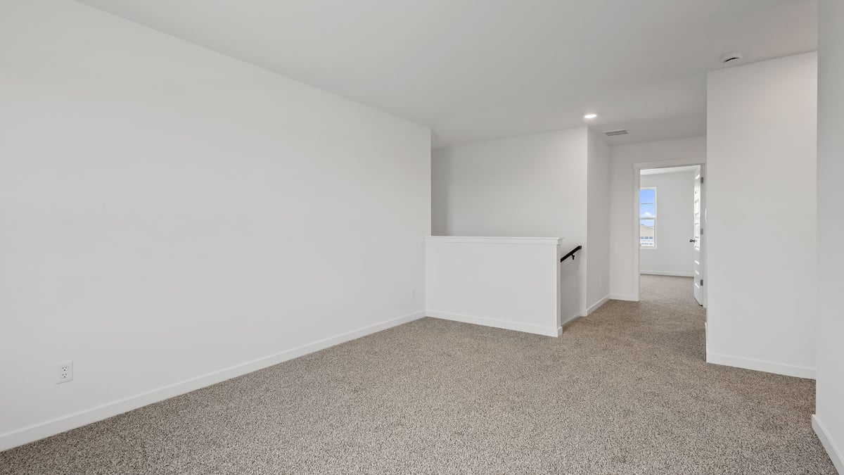 Loft area with carpeted floors and plenty of space.