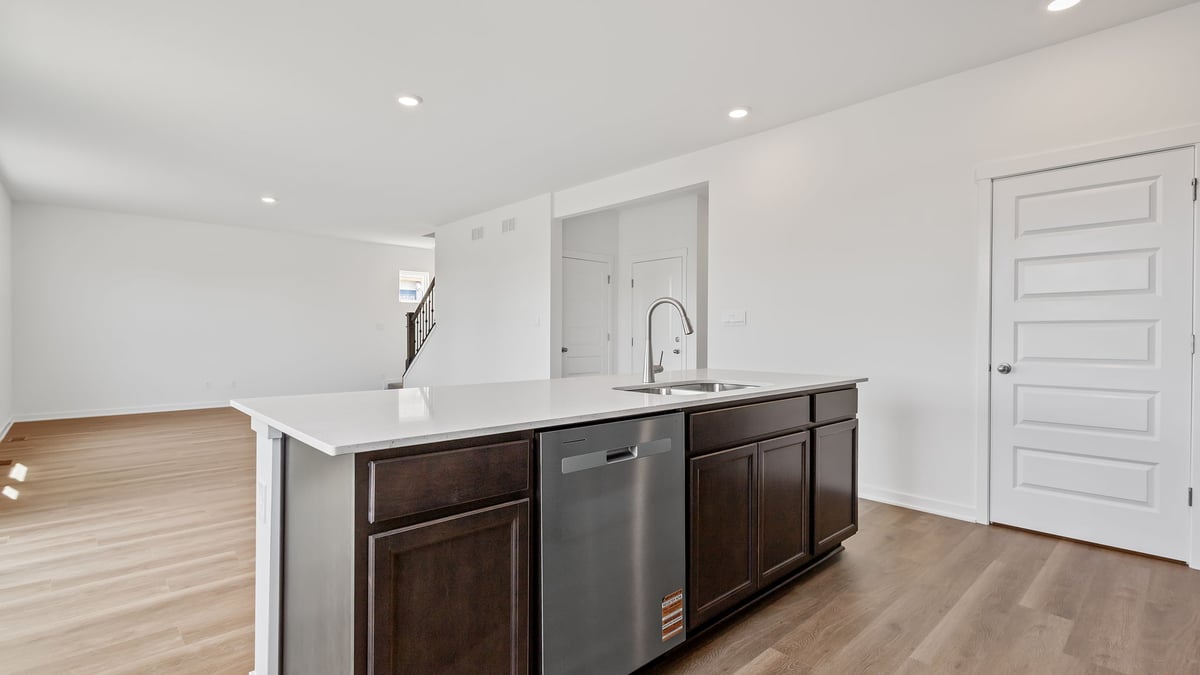 Kitchen island with quartz countertops and hard wood flooring.