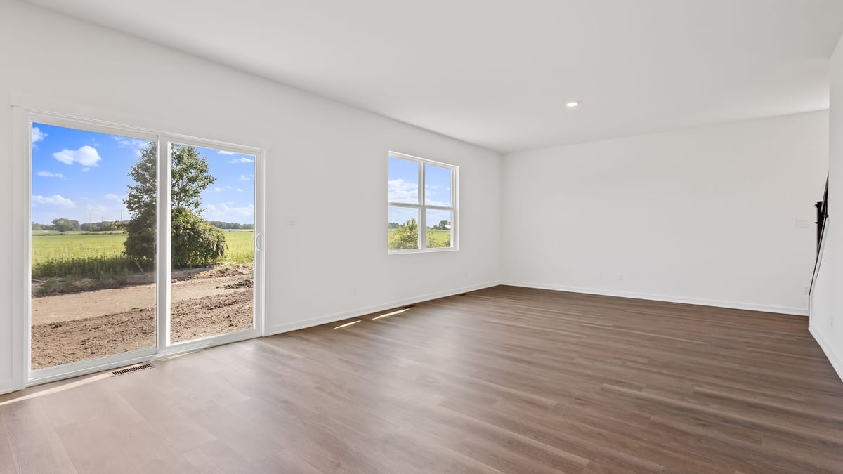Dining area and living space with windows and glass sliding doors.