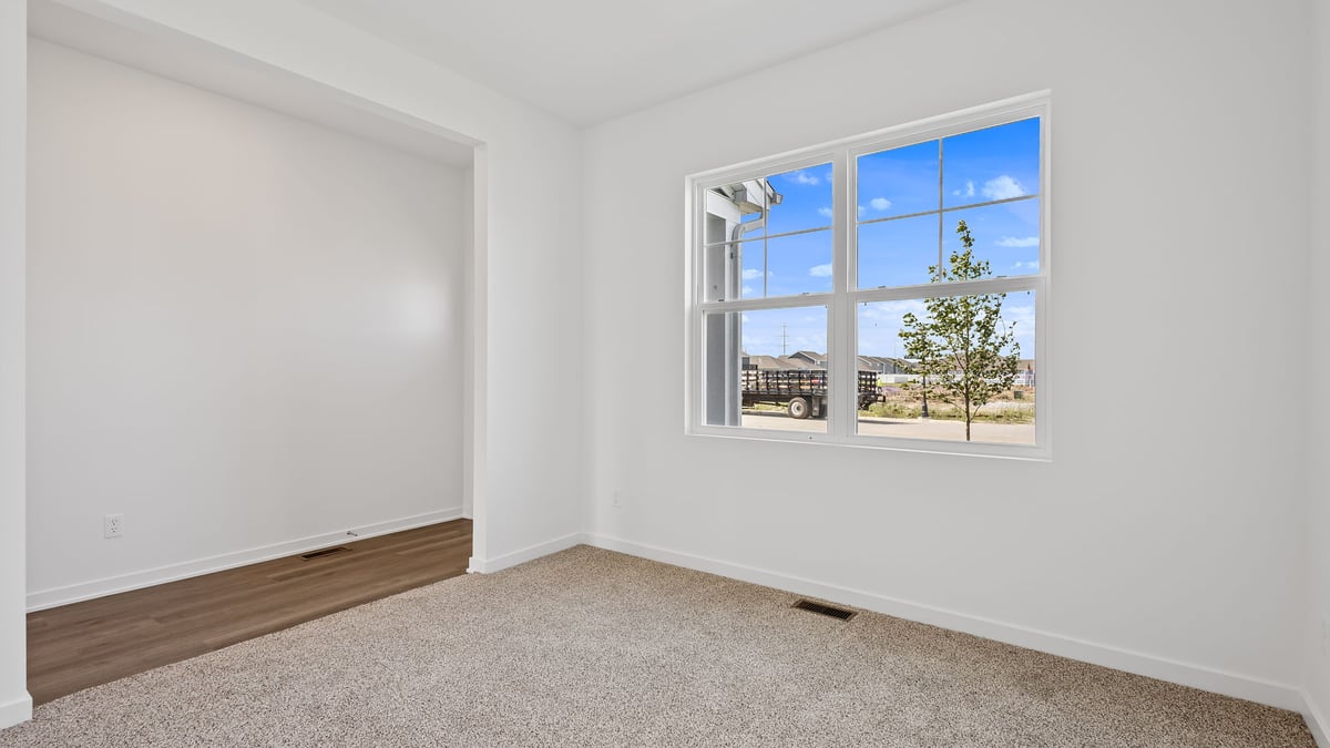 Front room area with carpeted floors and a big window.